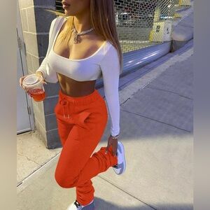 Stacked orange sweatpants